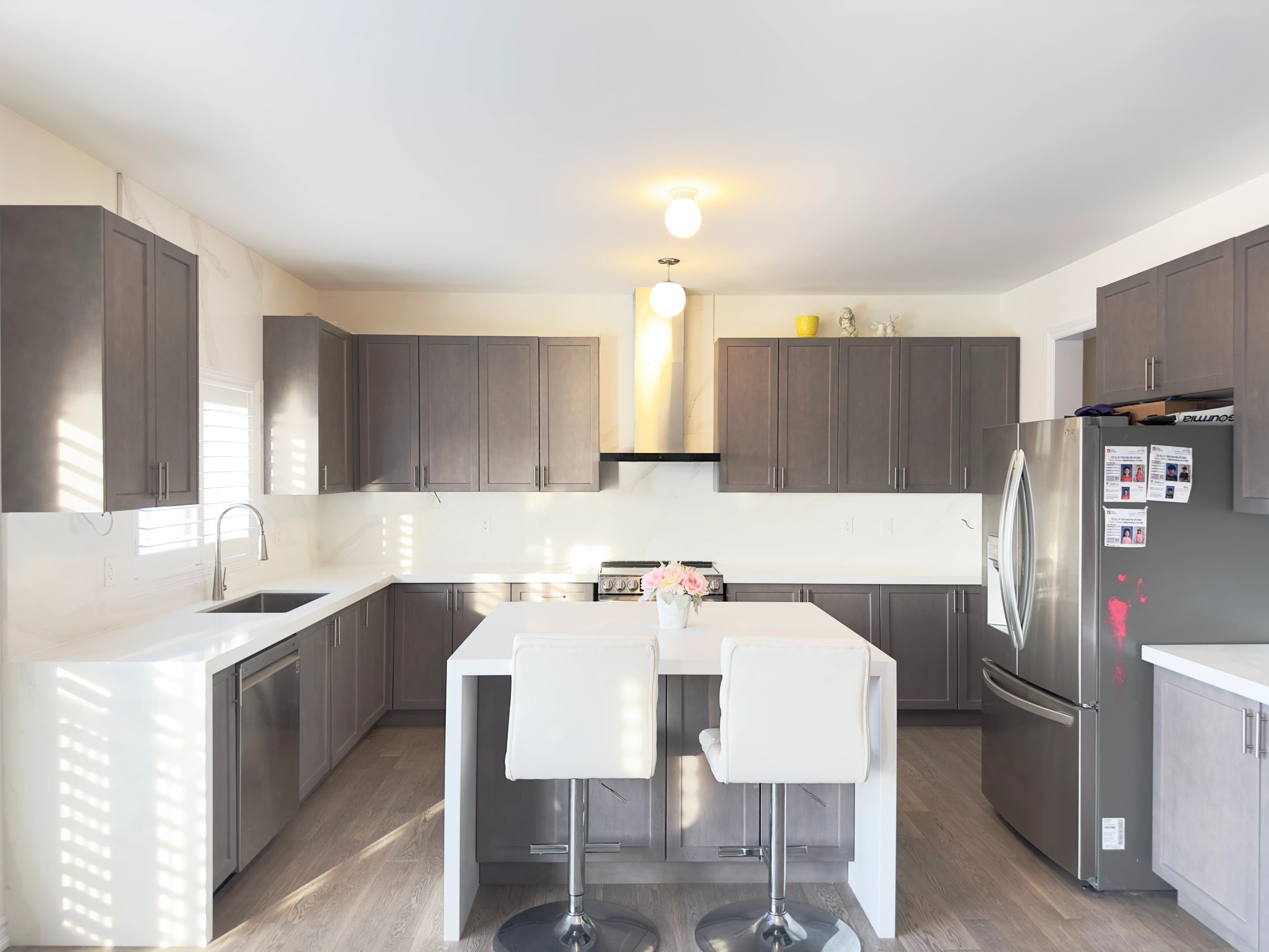 White stone island and countertops contrasting with dark kitchen cabinetry